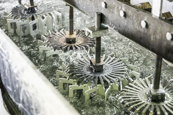 Aluminiumteile auf Gestellen im Eloxalbad